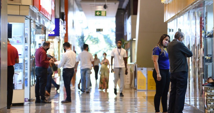 Mulher tira máscara, cospe nas mãos e esfrega em objetos de livraria